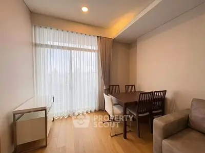 Modern dining area with wooden floor, elegant curtains, and cozy seating in a stylish apartment.