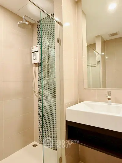 Modern bathroom with sleek shower and stylish sink in contemporary apartment.