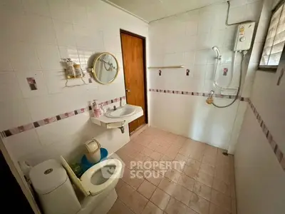 Spacious bathroom with shower and modern fixtures in a well-lit setting.