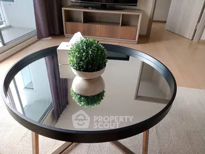 Modern living room with stylish round glass coffee table and elegant decor