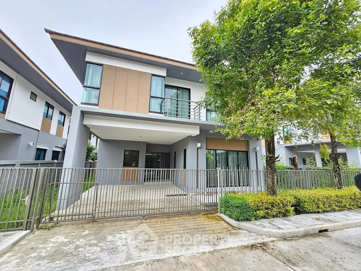Modern two-story house with sleek design and lush greenery in a serene neighborhood.