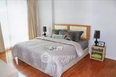 Spacious bedroom with elegant decor and natural light, featuring a cozy bed and stylish bedside tables.