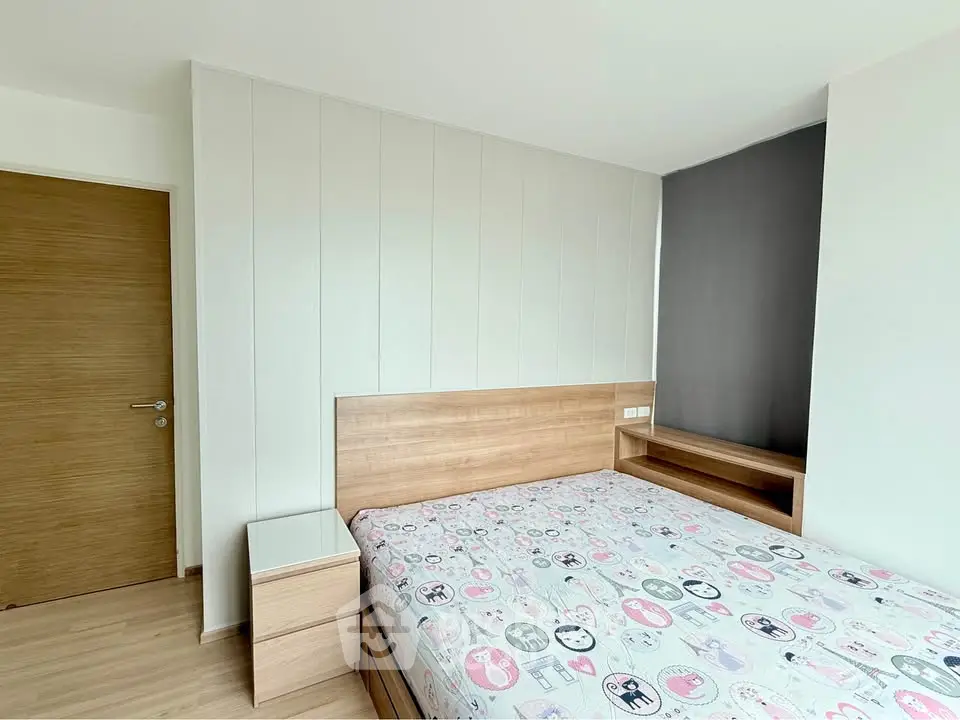 Modern bedroom with wooden furniture and stylish decor in a bright apartment.
