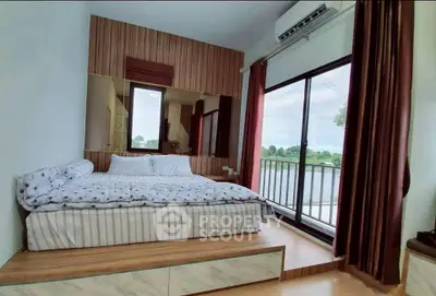Cozy bedroom with large window and scenic view, featuring modern decor and air conditioning.