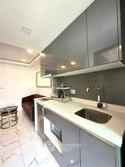 Modern kitchen with sleek cabinetry and cozy seating area