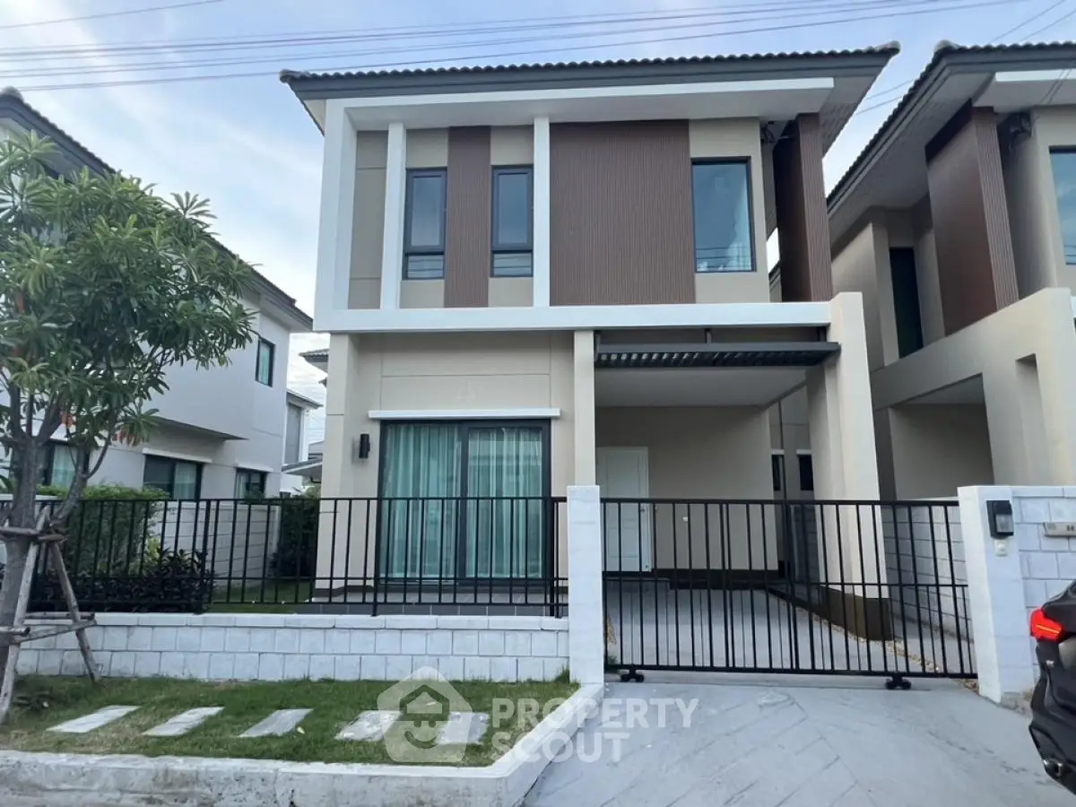 Modern two-story house with gated driveway and landscaped front yard