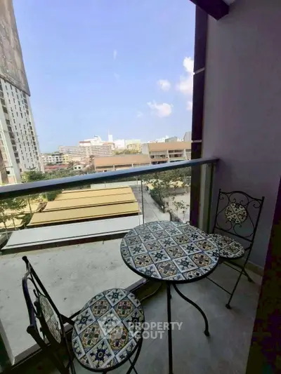 Charming balcony with stylish mosaic table and chairs offering city views.