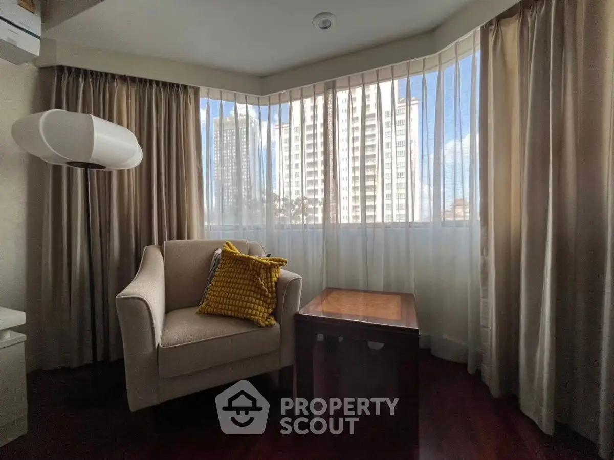 Cozy corner with armchair and city view through large windows