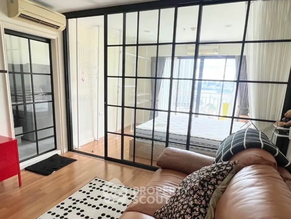 Modern living room with glass partition and cozy decor in a stylish apartment.