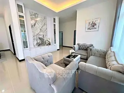 Luxurious living room with elegant gray sofas and marble accent wall, perfect for modern living.