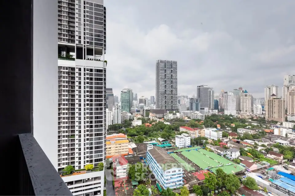 Stunning cityscape view from high-rise balcony overlooking urban skyline and lush greenery.