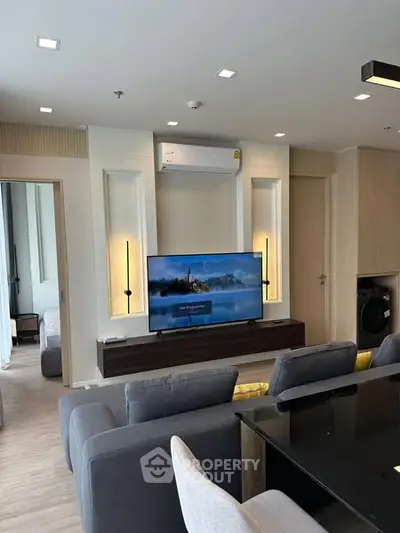 Modern living room with sleek furniture and wall-mounted TV in a stylish apartment.