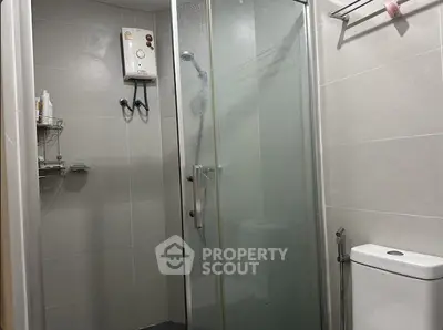 Modern bathroom with glass shower and sleek fixtures in contemporary apartment.