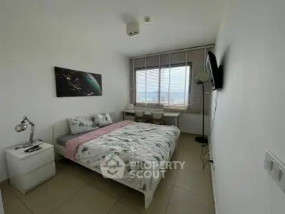 Cozy bedroom with large window and modern decor, perfect for relaxation.
