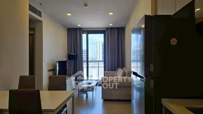 Modern living room with stylish furniture and large window offering city view