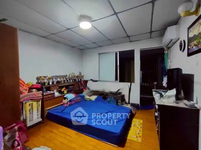 Cozy bedroom with wooden flooring and air conditioning, featuring a comfortable bed and ample storage space.