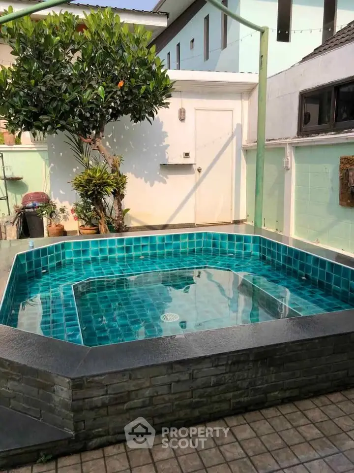 Charming backyard pool with turquoise tiles and lush greenery