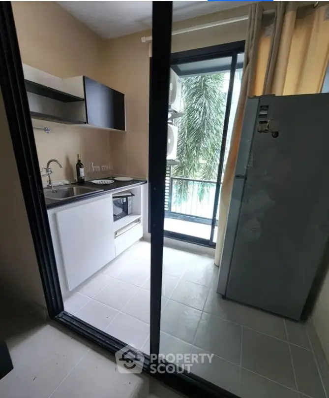 Modern kitchen with sleek appliances and balcony view in a stylish apartment.