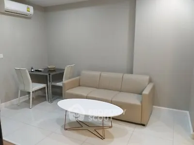 Modern living room with beige sofa and dining area in a cozy apartment.