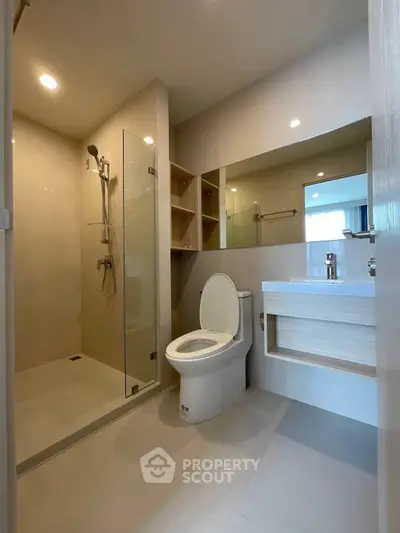 Modern bathroom with glass shower and sleek fixtures in a contemporary home.