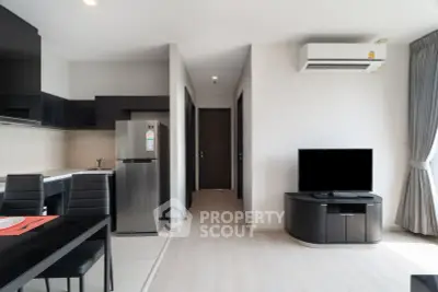 Modern apartment interior with sleek kitchen and cozy living area, featuring stylish furniture and natural light.