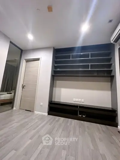 Modern living room with sleek built-in shelving and elegant flooring, perfect for stylish urban living.