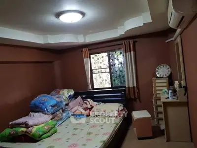 Cozy bedroom with window view, air conditioning, and ample storage space, perfect for comfortable living.