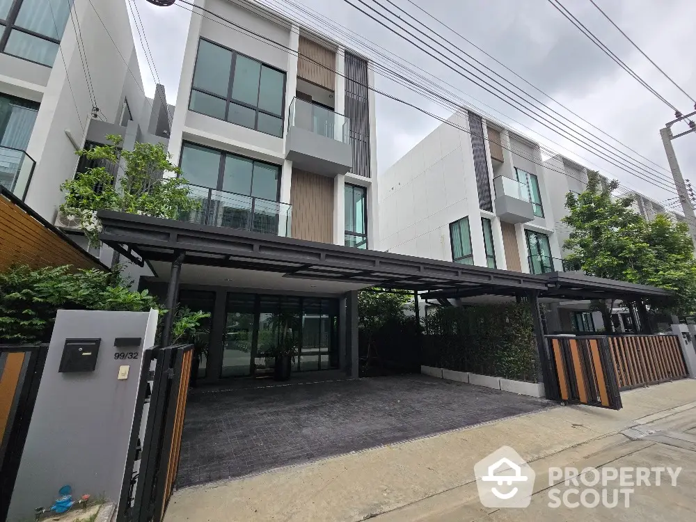 Modern townhouse exterior with large windows and sleek design in urban setting.