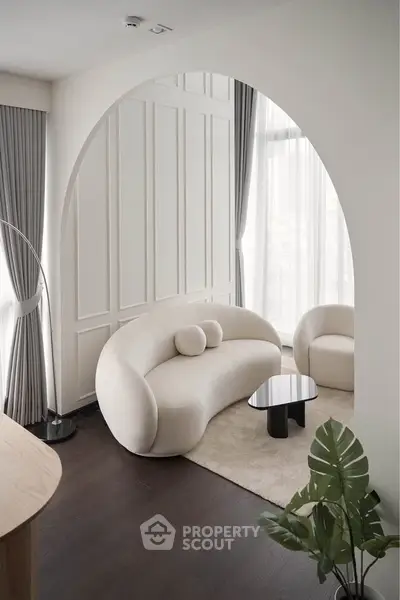 Elegant modern living room with unique curved sofa and floor-to-ceiling windows