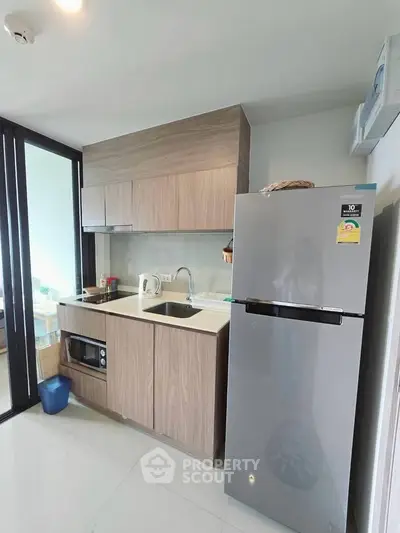 Modern kitchen with sleek appliances and stylish cabinetry in a contemporary apartment.