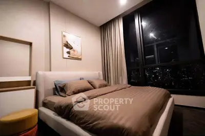 Luxurious bedroom with large window offering stunning city view, modern decor, and cozy ambiance.