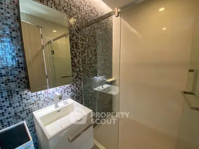 Modern bathroom with glass shower and mosaic tile wall