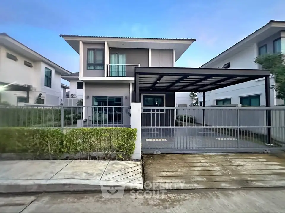 Modern two-story house with sleek design and spacious driveway in a suburban neighborhood.