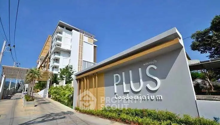Modern condominium building with stylish entrance and lush greenery.