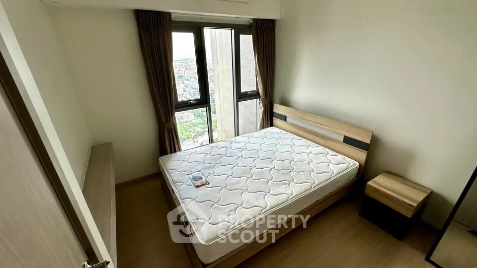 Modern bedroom with large windows and wooden furniture, offering a bright and cozy atmosphere.