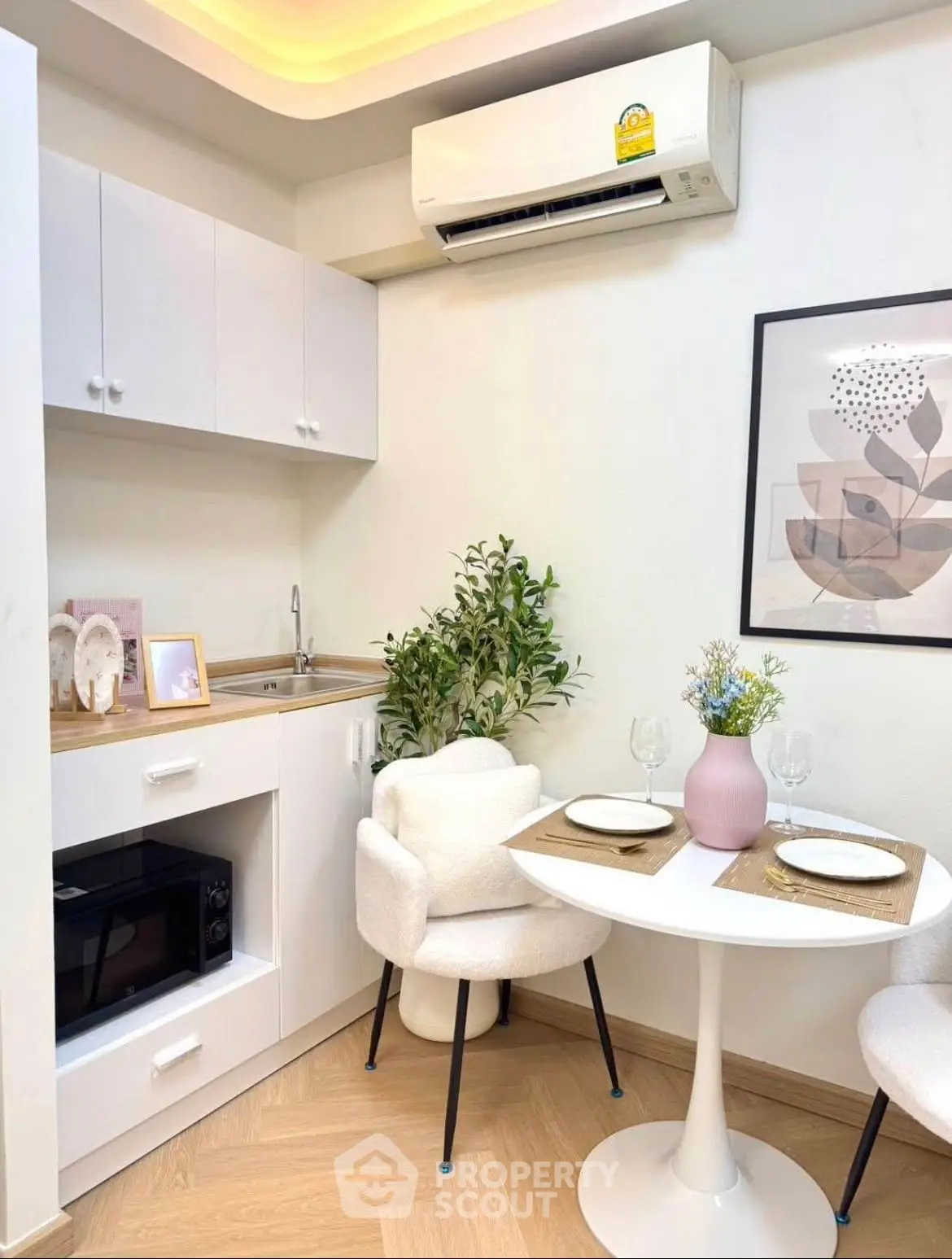Charming compact kitchen with dining area, featuring modern decor and cozy seating.