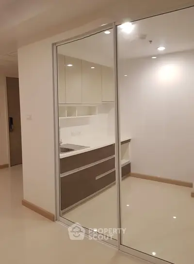 Modern kitchen with sleek cabinetry and reflective glass doors
