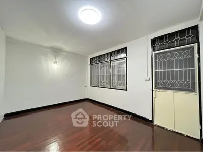 Spacious empty room with polished wooden floors and bright lighting, ideal for customization.
