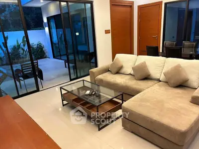Modern living room with cozy sectional sofa and glass doors leading to a stylish patio.