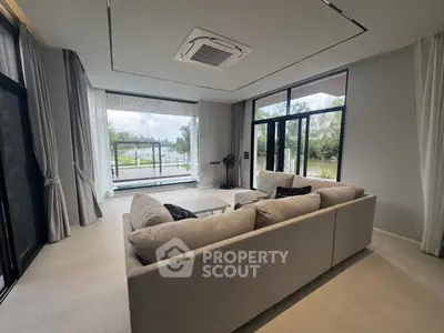Spacious living room with large windows and scenic view, modern interior design, cozy seating area.