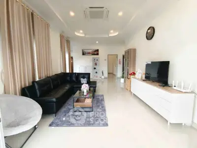 Spacious modern living room with sleek black sofa and stylish decor
