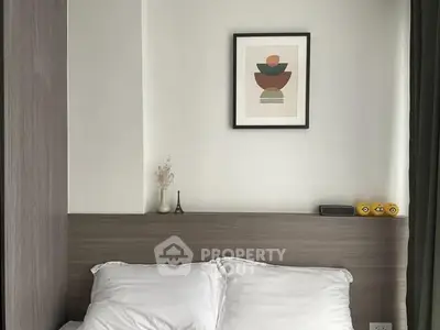 Cozy bedroom with modern decor and framed artwork above bed