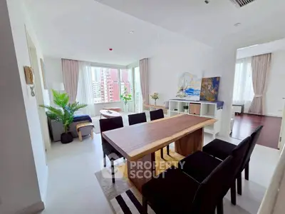 Spacious modern living room with elegant dining area and large windows offering city views.