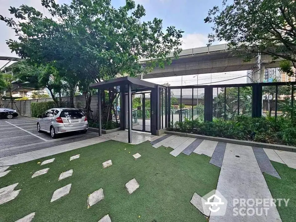 Modern parking area with green landscaping and sleek entrance design