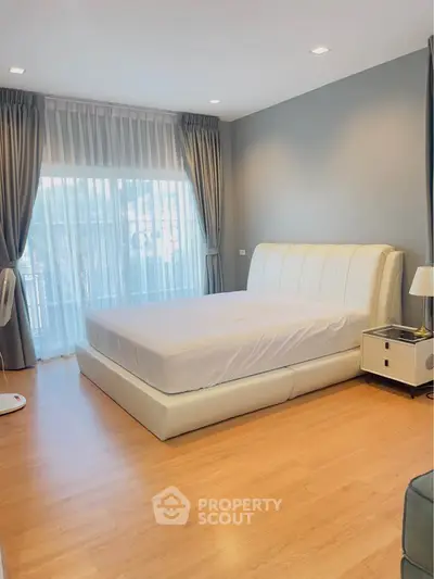 Spacious bedroom with elegant decor and large window for natural light