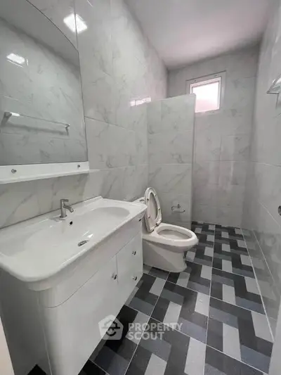 Modern bathroom with sleek white fixtures and stylish tile flooring
