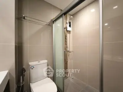 Modern bathroom with sleek shower and toilet in contemporary apartment.