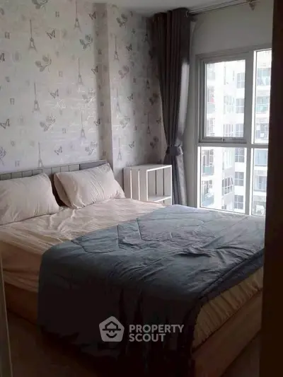 Cozy bedroom with large window and stylish wallpaper in modern apartment.