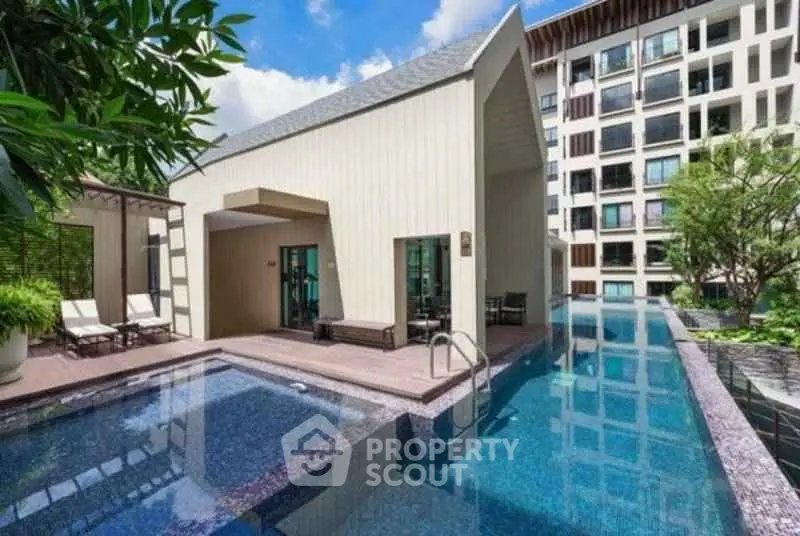Luxurious modern apartment complex with stunning outdoor pool and lush greenery.