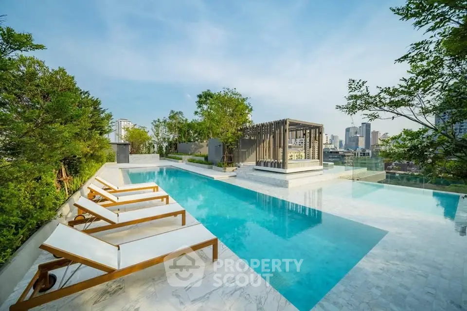 Luxurious rooftop pool with city skyline view and modern lounge chairs.